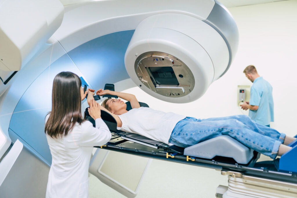 Cancer treatment in a modern medical private clinic or hospital with a linear accelerator. Professional doctors team working while the woman is undergoing radiation therapy for cancer